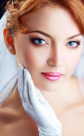 Braut mit roten Haaren und Handschuh hat Make-up
