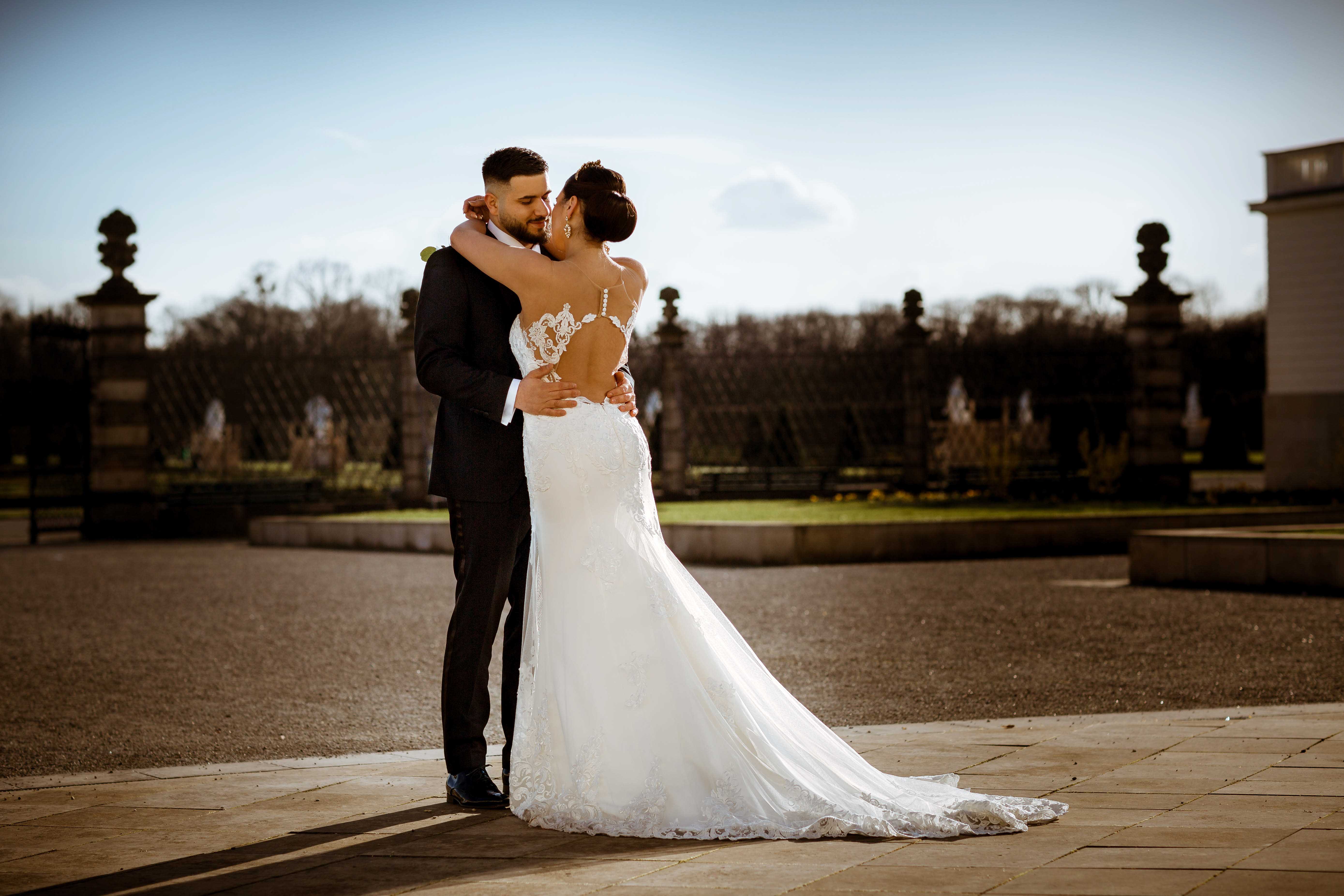 Hochzeitspaar eng umschlungen im Park