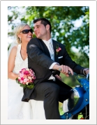 Bräutigam fährt blauen Roller mit Braut am Rücksitz